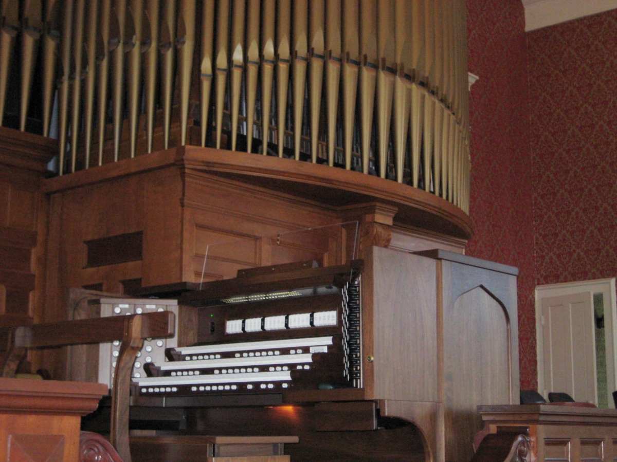 SPENCER CONGREGATIONAL CHURCH, SPENCER, MA - THREE MANUAL Spencer Congregational Church in Spencer, MA recently combined a 33 stop/36 rank Emmons-Howard pipe organ to 24/31 ranks of Allen Digital additions using a custom built 3 manual drawknob console. The resulting instrument has a specification of 57 stops/ 67 ranks. This custom designed instrument is a welcomed addition to a music program led by Sarah Rutkiewicz. The organ committee needed to address the shortcomings of their 35 year old console as well as the tonal limitations of their organ. The Emmons-Howard organ had gone through three major rebuilds in its life. It was conceived as a warm romantic organ with an orchestral breadth to its sound. However, work done in 1967 significantly altered the original design and introduced neo-baroque stops into its specification. Unfortunately, this attempt of unifying romantic and new-baroque elements was not successful. The committee decided to correct this battle of styles and replace the console. They unanimously found that the Allen Organ Company could address all their concerns with a collection of complementary digital pipe stops and a three manual Drawknob console. The new instrument’s specification includes of a new state trumpet, the addition of independent pedal stops and many new foundation stops and solo stops. The console also includes a comprehensive MIDI system with velocity sensitive keyboards.